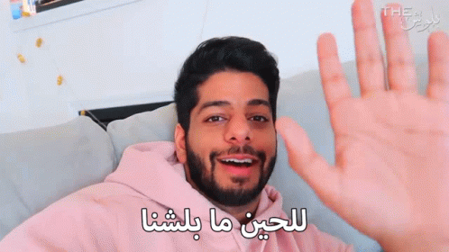 Bearded Man Waving Hand in Arabic on Couch
