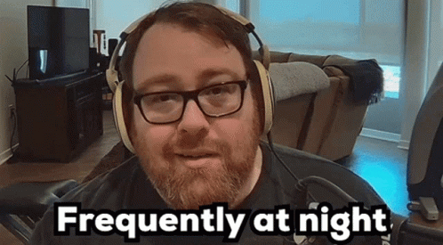 Bearded Man Wearing Headphones and 'He' Shirt