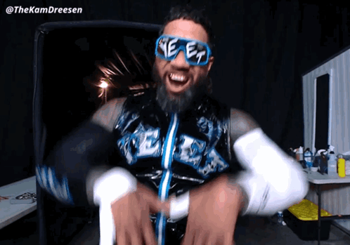 Bearded Man Wearing Sunglasses and 'ee' Vest