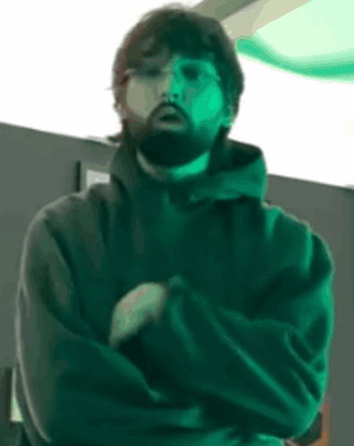 Bearded Man With Arms Crossed in Dark Room