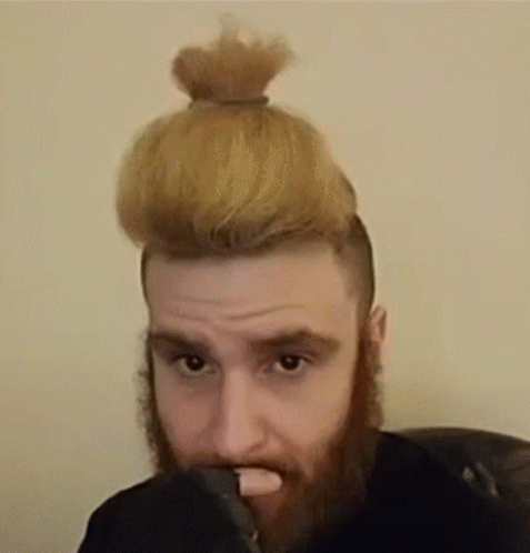 Bearded Man with Bun Looking at Camera