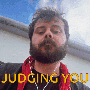 Bearded Man With Ear Buds and Red Bandana Judging You