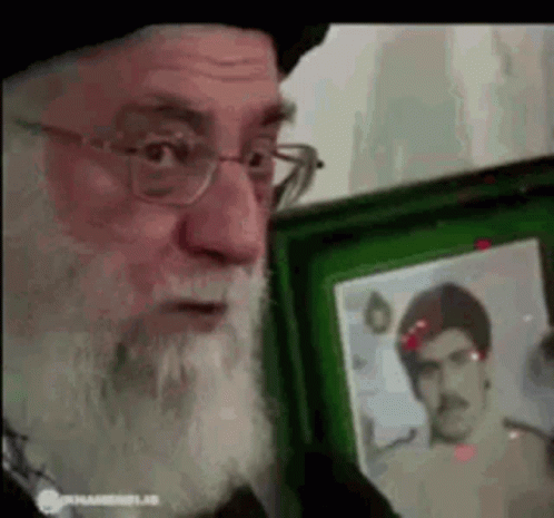 Bearded Man With Glasses Holding Picture in Green Frame