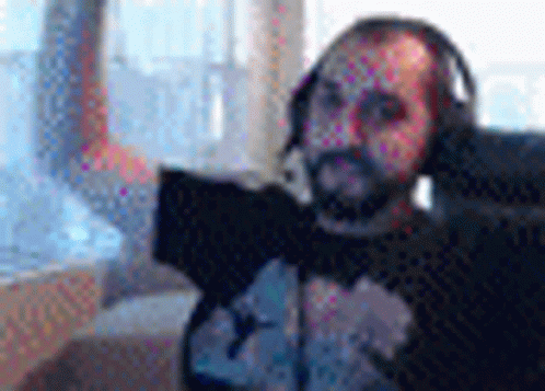Bearded Man With Headphones and Microphone at Laptop