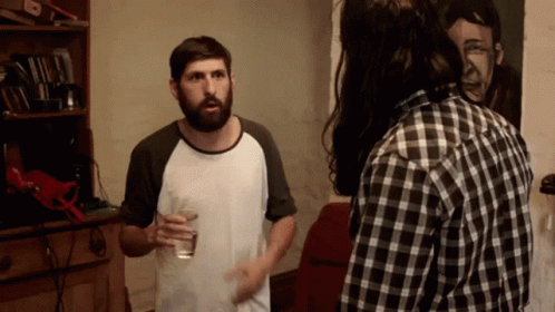 Bearded Man With Water Glass Talks to Plaid Shirt Man