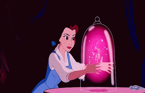 Belle From Beauty And The Beast Is Sitting At A Table With A Pink Flower Coming Out Of Her Hand . GIF