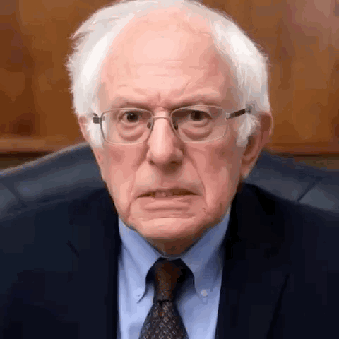Bernie Sanders Is Wearing Glasses And A Suit And Tie And Making A Funny Face . GIF