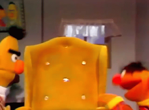 Bert And Elmo From Sesame Street Are Sitting In A Chair GIF