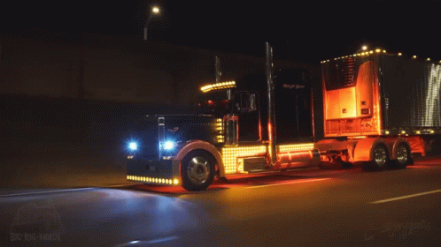 Big Rig Truck Driving Down Road at Night