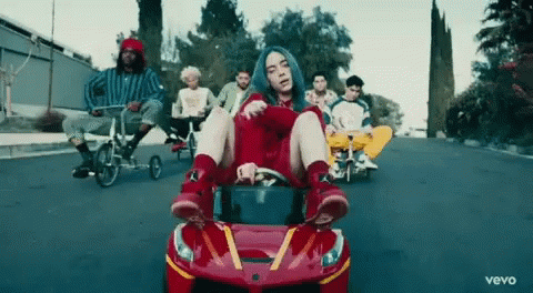 Billie Eilish Driving Red McDonald's Car With Group Riding Bikes Behind