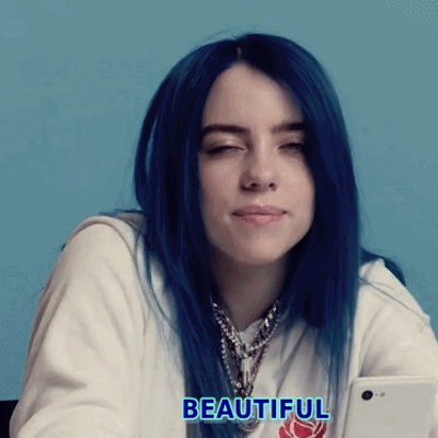 Billie Eilish With Blue Hair Is Holding A Cell Phone In Her Hand . GIF