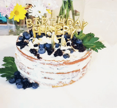Birthday Cake with Blueberries and Candles Saying Happy