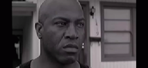 Black And White Bald Man Looking At Camera Before House GIF