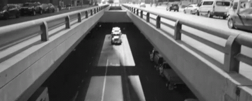 Black and White Car Driving Under Bridge