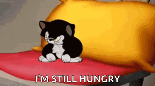 Black And White Cartoon Cat On Red Blanket Next To Yellow Pillow GIF