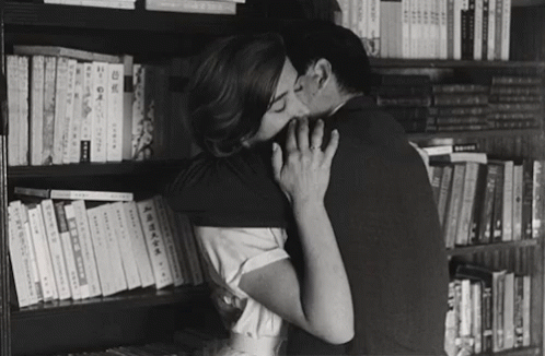 Black and White Couple Kissing by Bookshelf