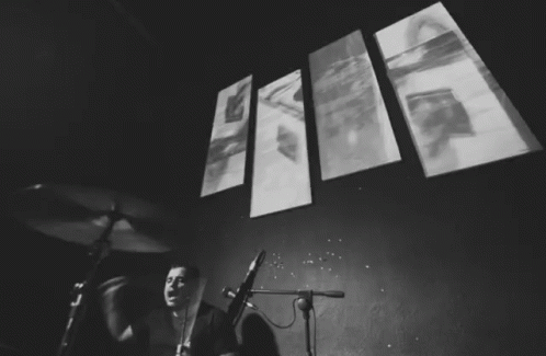 Black And White Drummer With Wall Of Images GIF