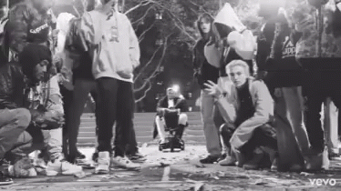 Black and White Group Standing Around Wheelchair