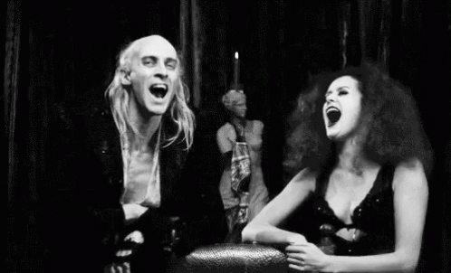 Black And White Man And Woman Laughing In Front Of Statue GIF