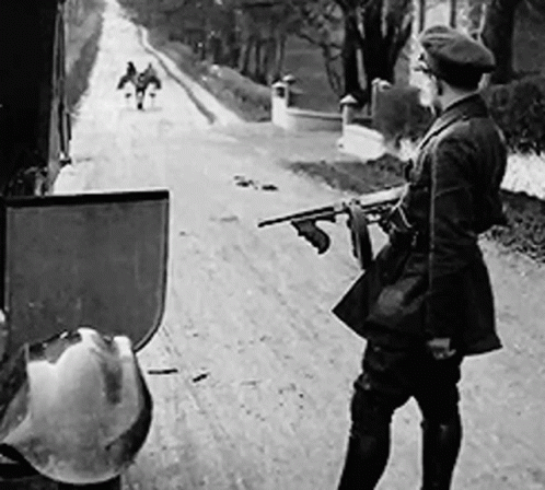 Black and White Man Holding Gun on Dirt Road