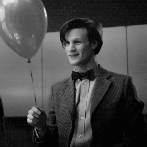 Black and White Man in Suit Holding Balloon