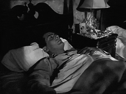 Black and White Man Laying in Bed With Lamp