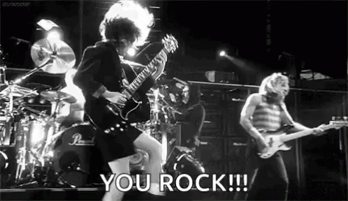 Black and White Man Playing Guitar on Stage Saying You Rock