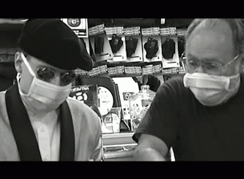 Black and White Men in Masks Near Remote Controls