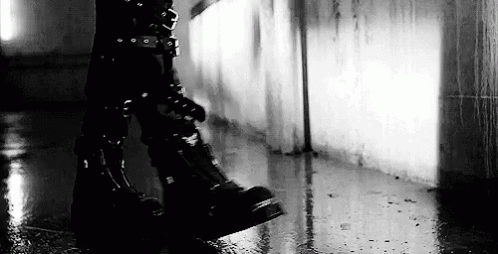 Black and White Person in Black Boots Walking in Rain