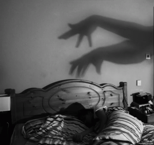 Black and White Person Laying on Bed With Hand Shadow