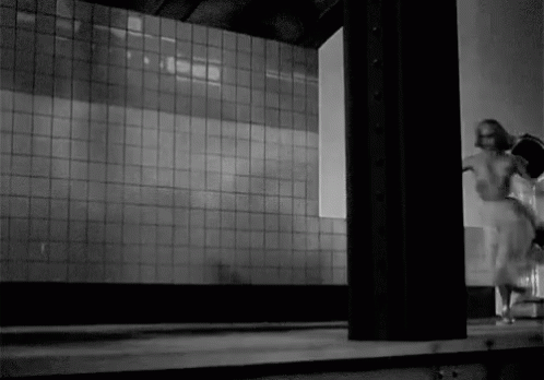 Black and White Person Standing in Front of Wall