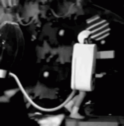 Black and White Person Standing Next to Microphone and Light Bulb