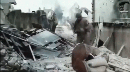 Black and White Photo of Destroyed City With Soldiers Walking Through Rubble
