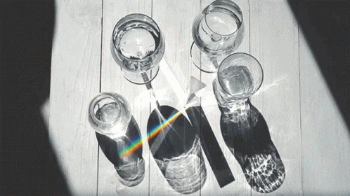 Black and White Photo of Glasses of Water and a Prism