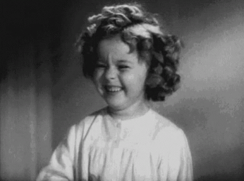 Black And White Photo Of Little Girl With Curly Hair Smiling GIF