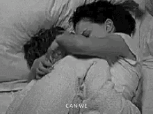 Black And White Photo Of Man And Woman Hugging In Bed GIF