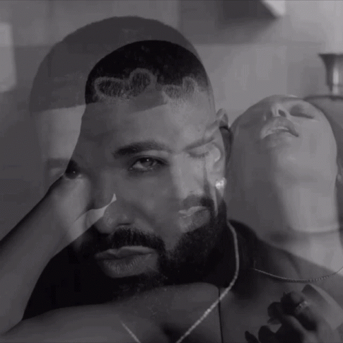 Black and White Photo of Man and Woman With Drake on His Head