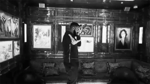 Black And White Photo Of Man In Room With Couch And Paintings GIF
