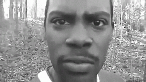 Black and White Photo of Man's Face in Forest