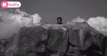 Black And White Photo Of Man Standing On Rock GIF