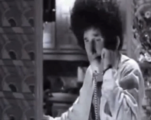 Black and White Photo of Man Talking on Telephone
