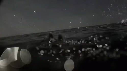 Black and White Photo of People Swimming in Ocean