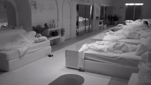 Black and White Photo of Room Filled with Beds