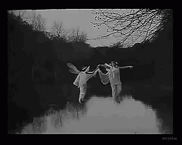 Black And White Photo Of Two People Holding Hands In River GIF