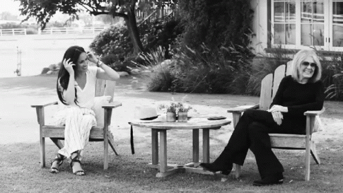 Black and White Photo of Two Women Sitting on Lawn Chairs