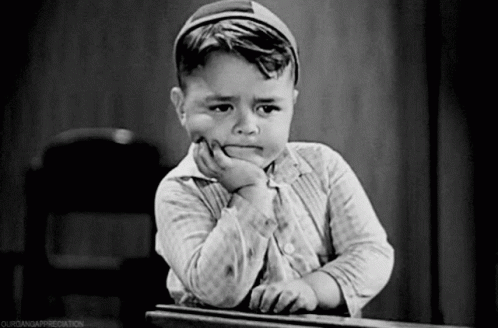 Black and White Photo of Young Boy With Hand on Chin