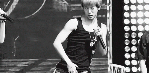 Black and White Photo of Young Man Singing Into Microphone