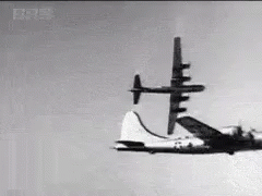 Black and White Plane Flying Through Blue Sky