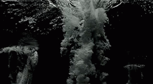 Black and White Wave Crashing on Rocky Shore