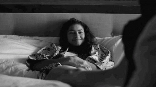 Black And White Woman Laying On Bed With Man GIF